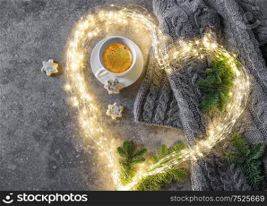 Coffee, cookies and heart shaped lights. Knitted sweater with Christmas tree branches