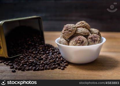 coffee cookies in a white plate with coffee beans on wooden brown table