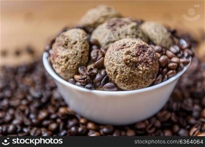 coffee cookies in a white plate with coffee beans on wooden brown table