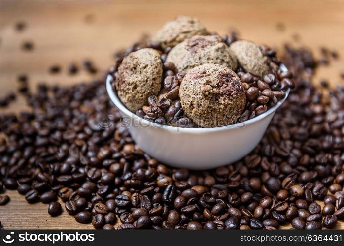 coffee cookies in a white plate with coffee beans on wooden brown table