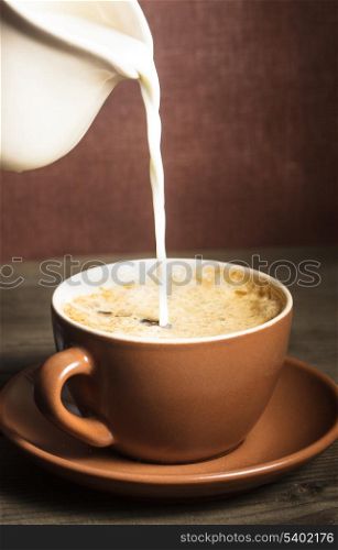 Coffee cup and a pouring milk