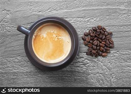 Coffee cup and beans on grunge wooden background