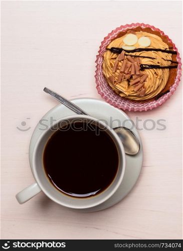 coffee cup and cake cupcake on wooden kitchen surface top view