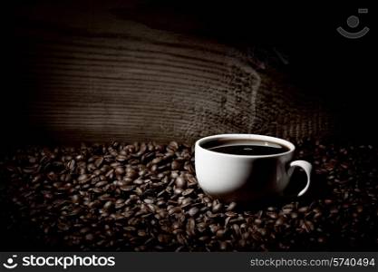 Coffee cup and coffee beans on old wooden background. Coffee cup and beans