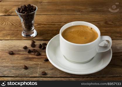 Coffee cup and coffee beans on rustic background. Cup of coffee. Strong coffee. Morning coffee. Coffee break. Coffee mug. Coffee cup.. Coffee cup and coffee beans on rustic background