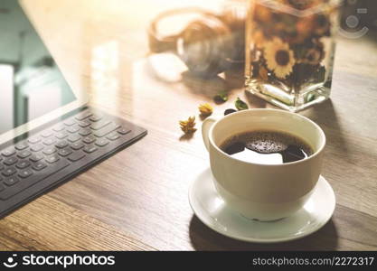 Coffee cup and Digital table dock smart keyboard,vase flower herbs,music headphone,eyeglasses on wooden table,filter effect