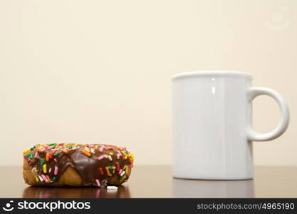 Coffee cup and doughnut on a desk