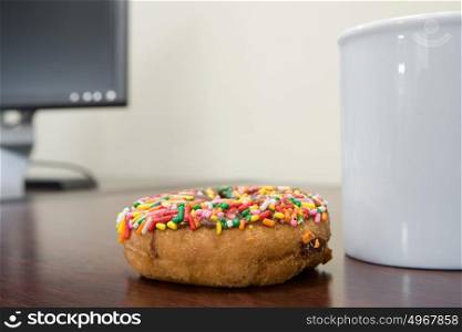 Coffee cup and doughnut on desk