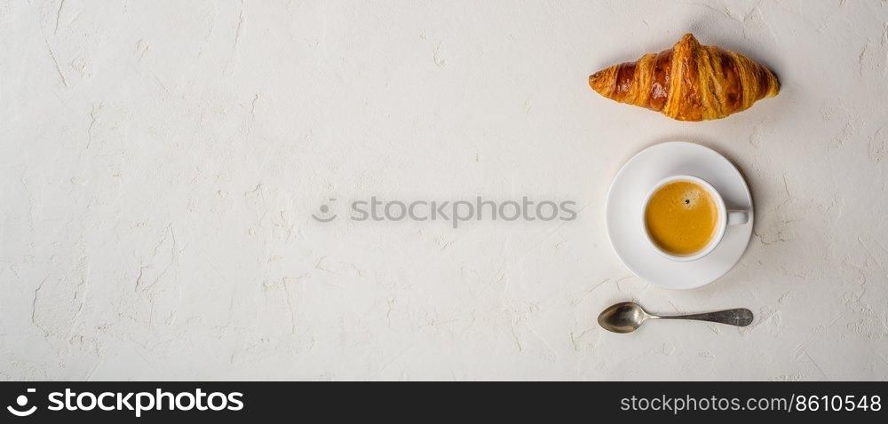 Coffee cup and fresh baked croissants on rusticbackground. Top View, Copyspace. Coffee and croissant, flat lay, top view