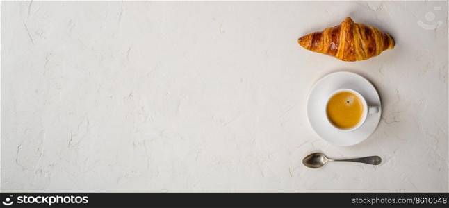 Coffee cup and fresh baked croissants on rusticbackground. Top View, Copyspace. Coffee and croissant, flat lay, top view