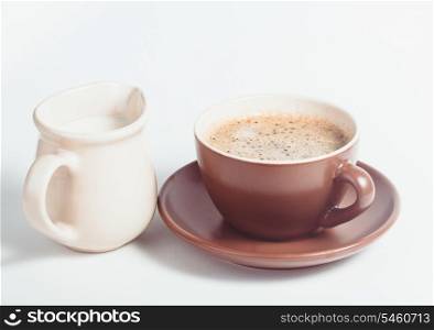 Coffee cup and milk jug on a white background