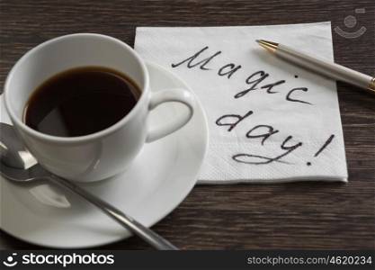 Coffee cup and napkin with message. Magic message written on napkin on wooden table