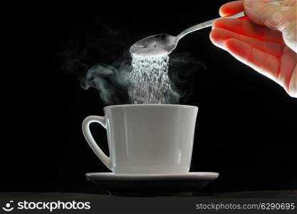 Coffee cup and pouring sugar spoon on white background