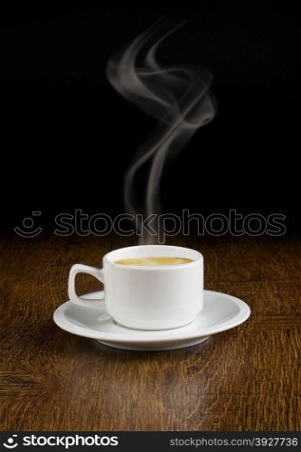 Coffee cup and saucer on a wooden table. Dark background.