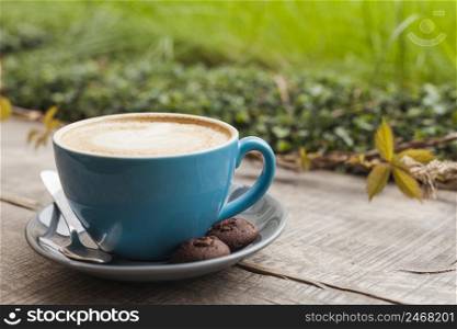 coffee cup cookies wooden surface with defocus green nature background