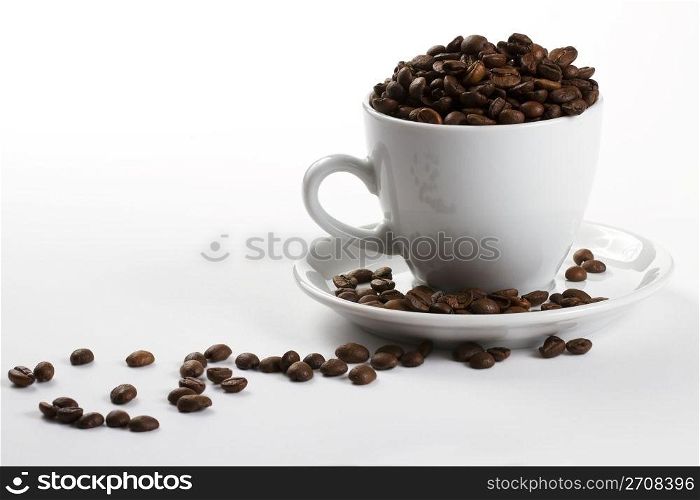 coffee cup filled with coffee beans. one coffee cup filled with coffee beans on white background
