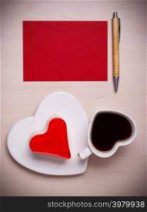 Coffee cup jelly cake in form of heart and red paper blank with pen on wooden surface, top view copy space for text
