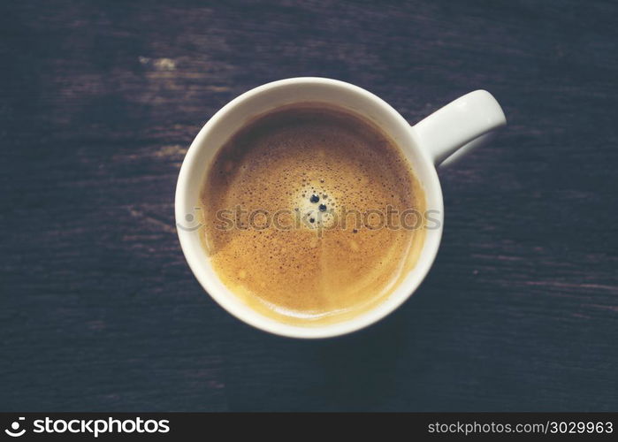 coffee cup on old wooden table background, vintage filter image