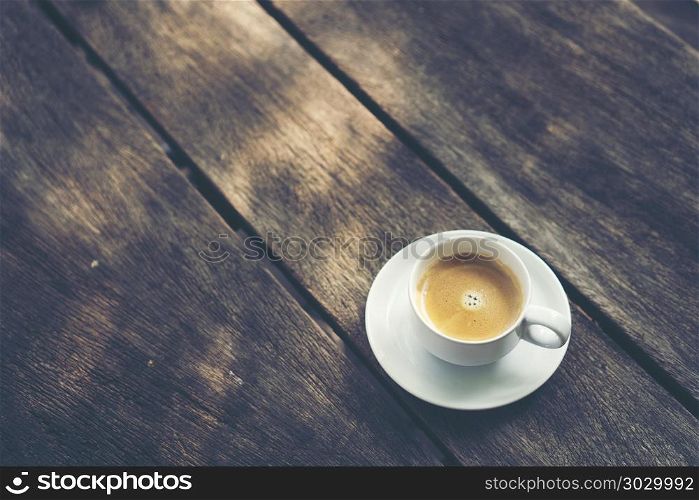 coffee cup on old wooden table background, vintage filter image