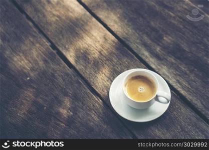 coffee cup on old wooden table background, vintage filter image