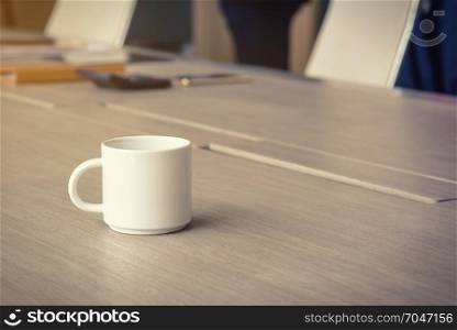coffee cup on the office desk, business office background concept, selective focus