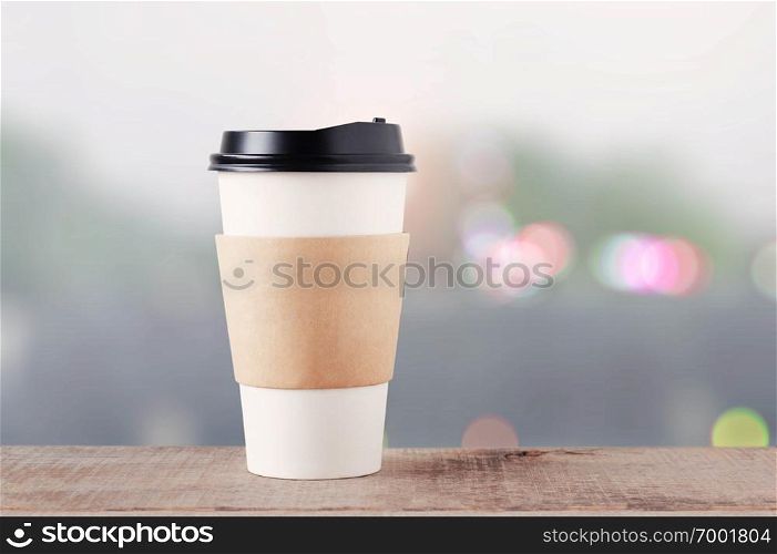 Coffee cup on wooden floor with bokeh background.