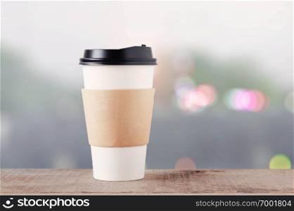 Coffee cup on wooden floor with bokeh background.