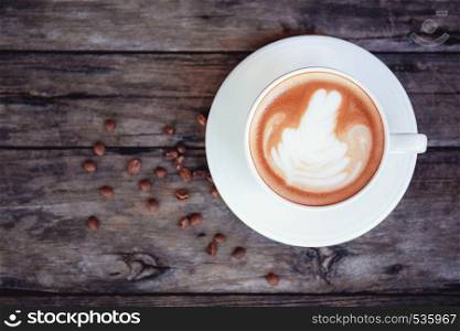 Coffee cup on wooden table with top view background.