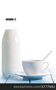 Coffee cup with a bottle of fresh milk