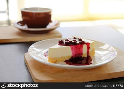 coffee cup with blueberry cheese pie on wooden plate, coffee break