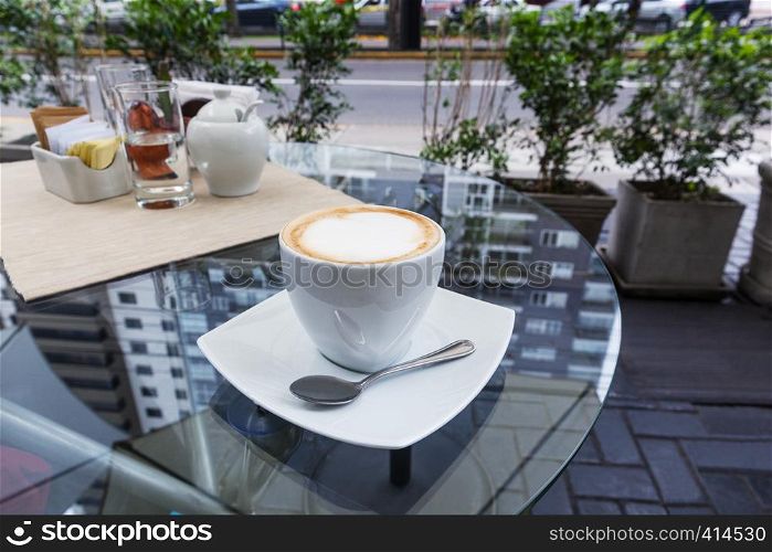 coffee cup with cappuccino on a table in cafe
