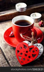 Coffee Cup with heart symbols. Red Cup with black coffee and decorative wooden heart.Selective focus
