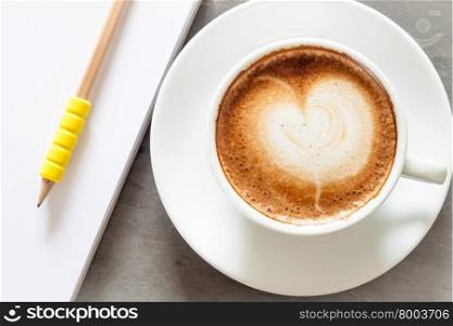 Coffee cup with notepad on grey background, stock photo