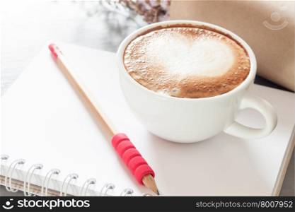 Coffee cup with notepad on grey background, stock photo