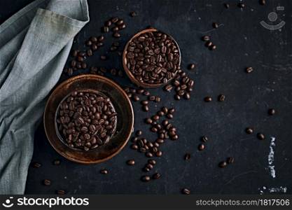 Coffee cup with roasted beans on dark background. Top view with copy space for your text. Coffee cup with roasted beans