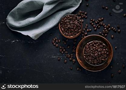 Coffee cup with roasted beans on dark background. Top view with copy space for your text. Coffee cup with roasted beans