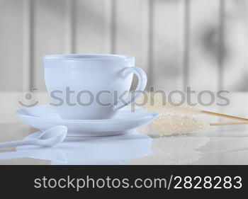 coffee cup with spoon and sugar stickon white table