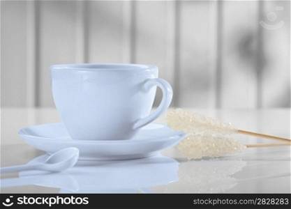 coffee cup with spoon and sugar stickon white table