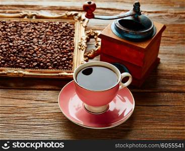 Coffee cup with vintage grinder on wooden old table