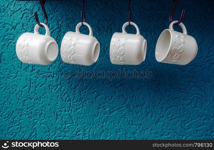 coffee cups hanging on hooks of blue kitchen wall modern interior design. coffee cups hanging on hooks of blue kitchen wall modern interior