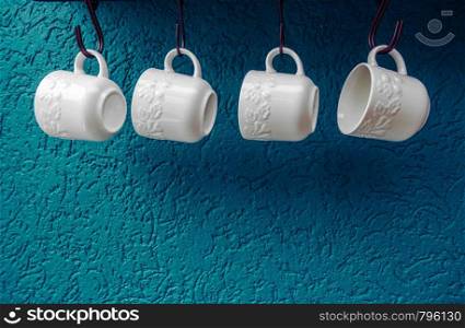 coffee cups hanging on hooks of blue kitchen wall modern interior design. coffee cups hanging on hooks of blue kitchen wall modern interior