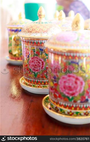 Coffee cups with antique Thai pattern on wooden table