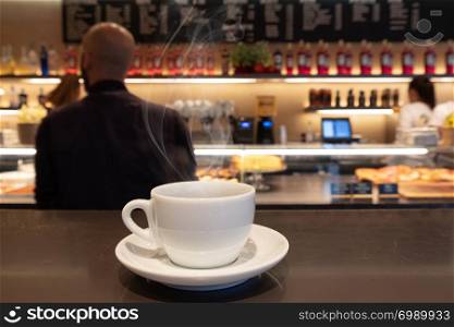 Coffee drink on wooden table with blur cafeteria as background