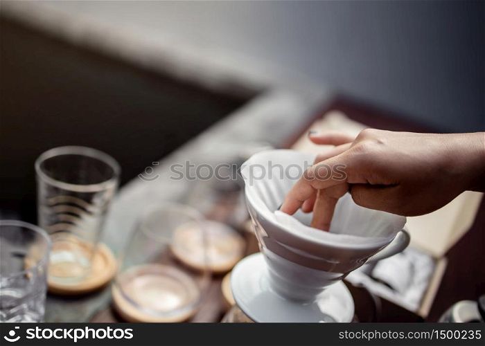 Coffee Drip Concept. Making Hot Drink at Home. Preparing a Paper Filter on a Ceramic Dripper