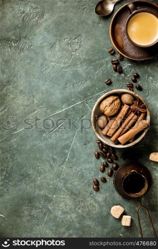 Coffee, flowers and spices on old green background, flat lay, space for text