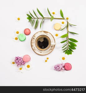 Coffee, french cookies macaroons, spring flowers. Floral flat lay. Minimal concept