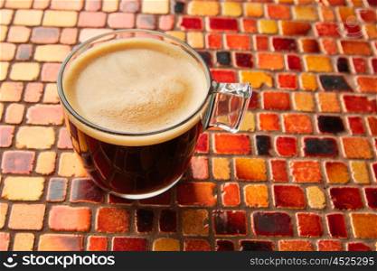 Coffee glass cup with cream on tiles red brown golden table