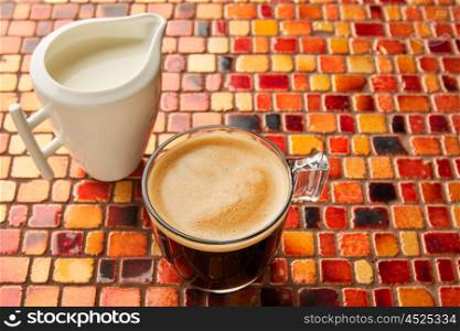 Coffee glass cup with cream on tiles red brown golden table