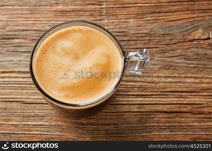 Coffee glass cup with cream on wooden table