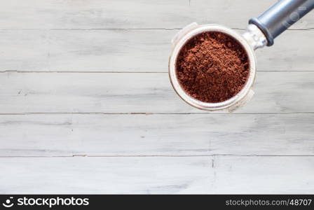 Coffee grind in group on white wooden wall texture background